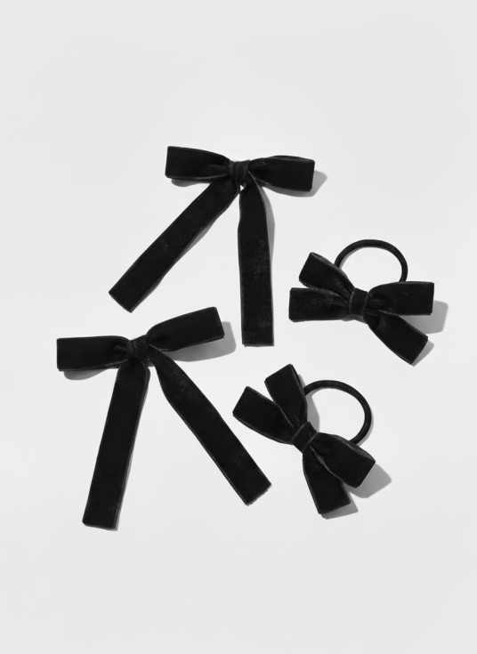 Melnas samta matu sprādzes un gumijas komplekts meitenēm uz gaiša fona