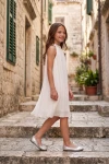 Balta plisēta kleita meitenēm Rozalia – uz kāpnēm brīvā dabā, skats no sāniem